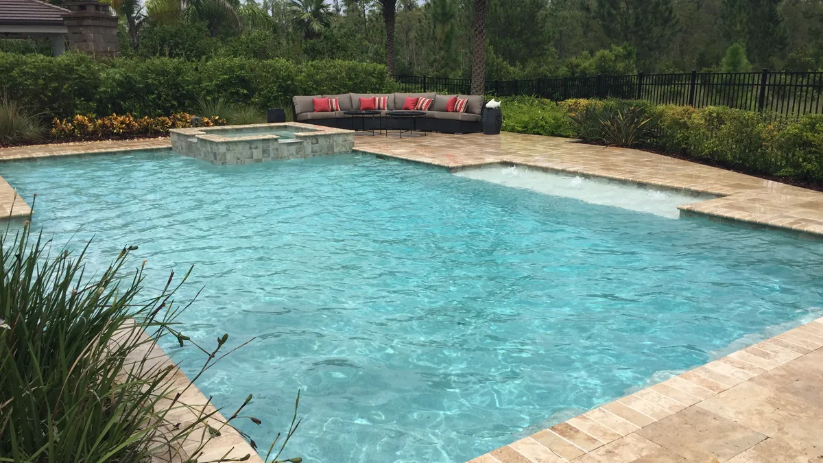 Aerial view of custom pool with sectional lounge and tropical landscaping, Odessa FL