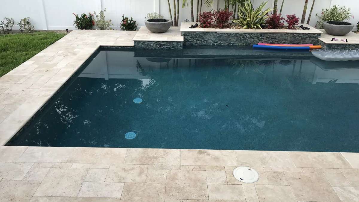 Rectangular pool with dark PebbleTec finish and tropical landscaping, Tampa FL