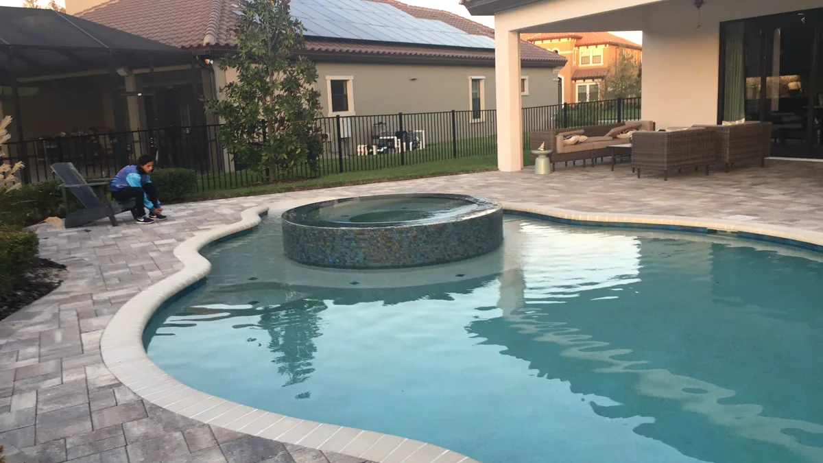 Freeform custom pool with raised round spa and iridescent mosaic tile, Lutz FL