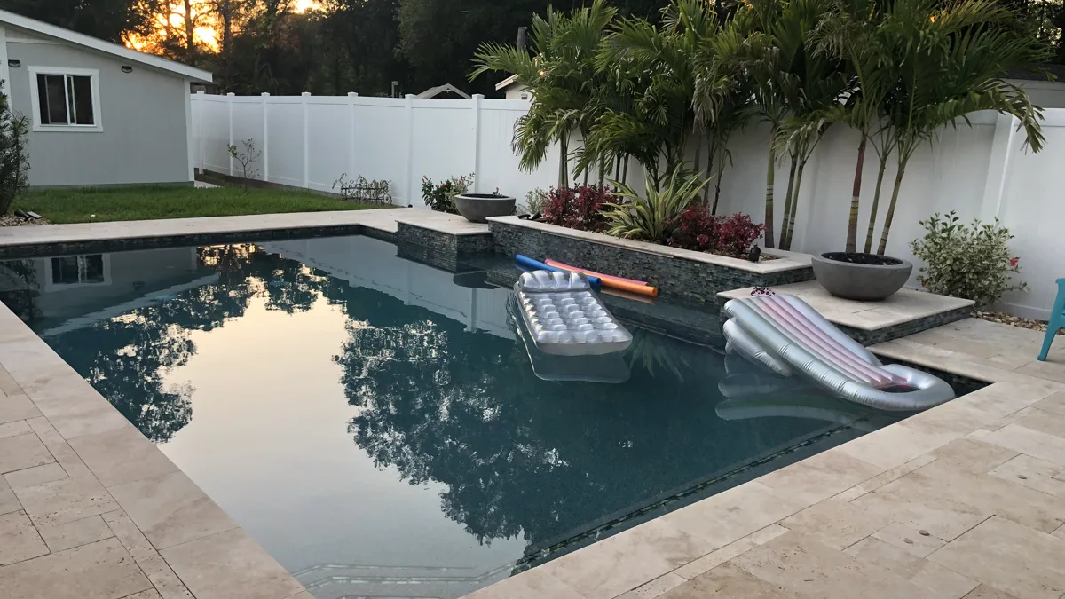 Custom shotcrete pool with palm trees and waterfall feature at golden hour, Tampa Bay FL