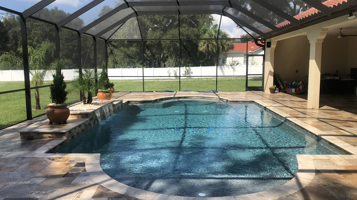 Screen-enclosed custom pool with tile-roof pavilion and travertine deck, Odessa FL