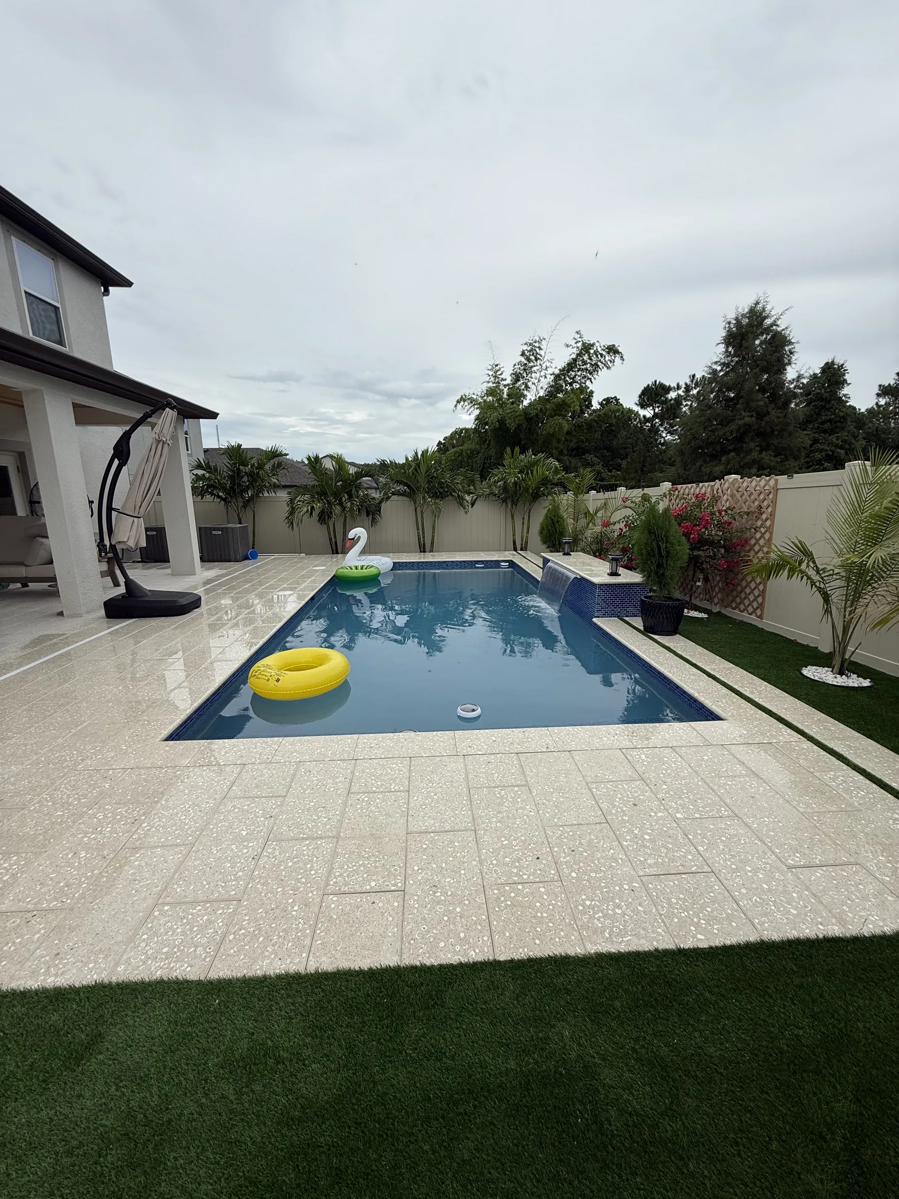 Finished rectangular blue pool with deck and enclosure, Trinity FL