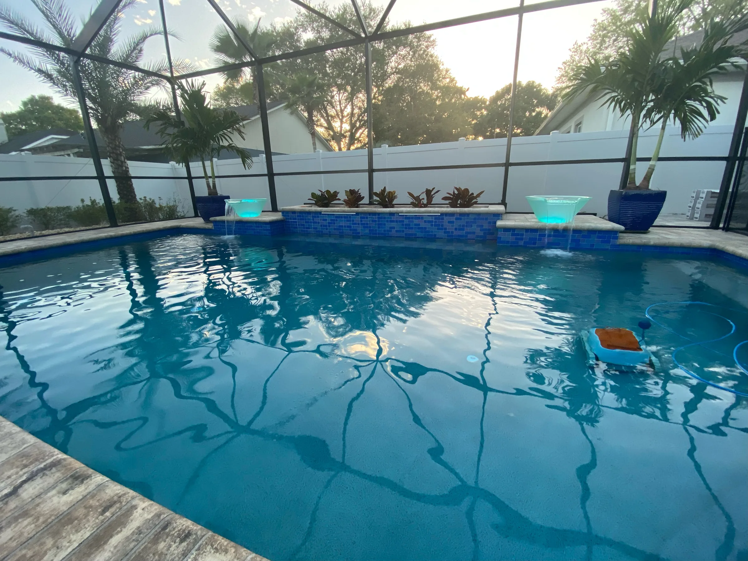 Classic screen-enclosed pool with illuminated mosaic water features, Tampa FL