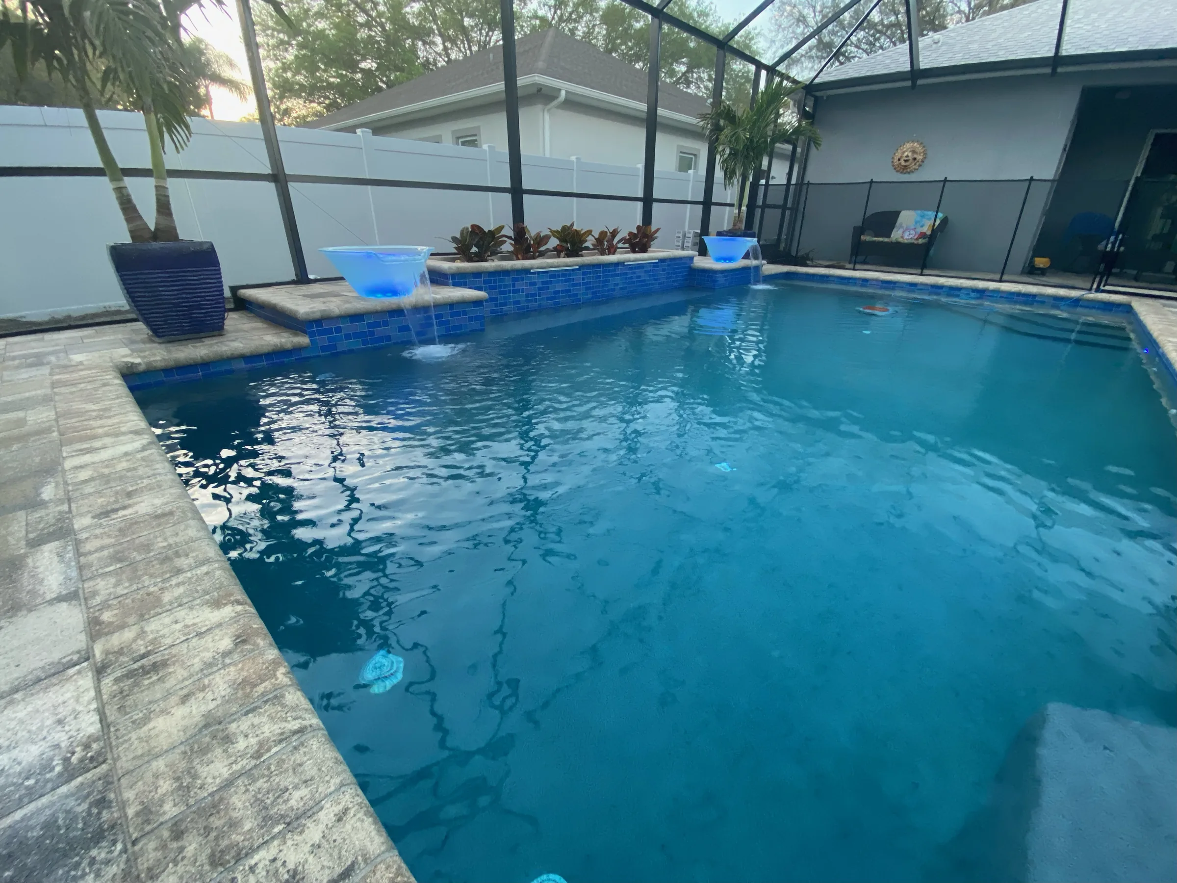 Screen enclosure interior with custom pool and illuminated water features, Tampa FL