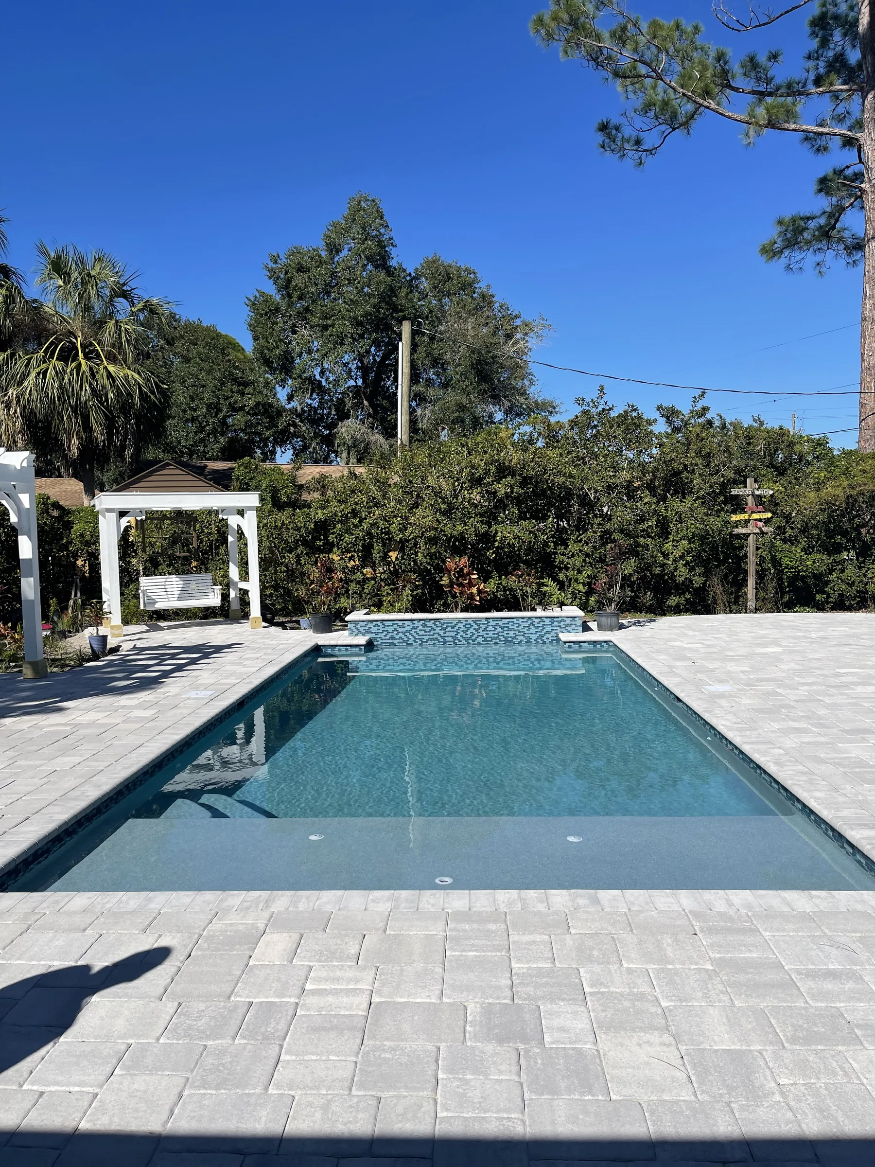 Custom pool with white pergola and mosaic spa accent, Tampa FL