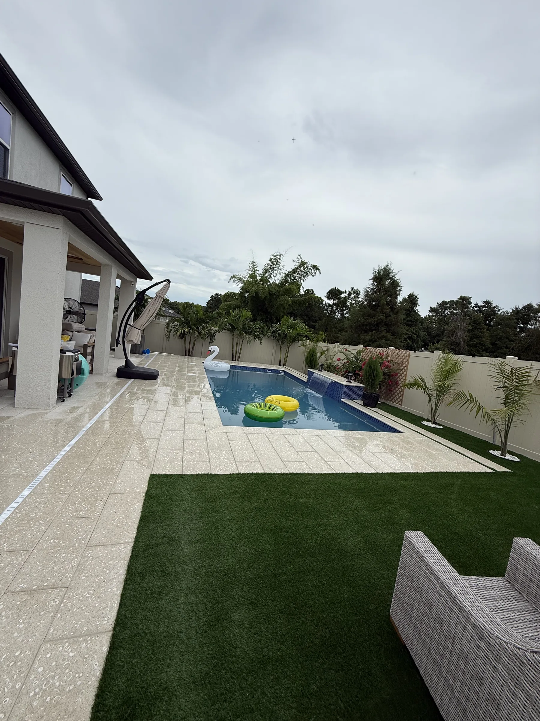 Wide view of finished enclosed rectangular pool with landscaped border, Trinity FL