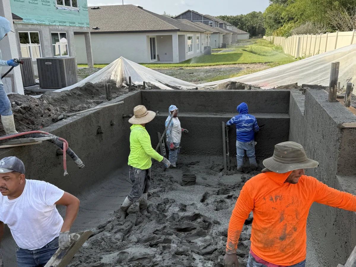 Shotcrete pool construction in progress with crew applying concrete, Tampa Bay FL