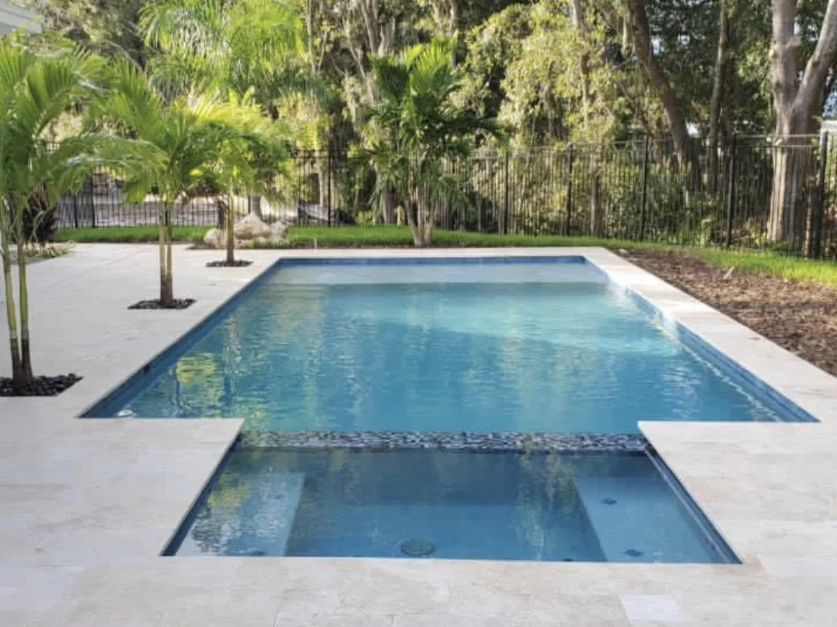 Rectangular saltwater pool with floats and modern home in background, Wesley Chapel FL